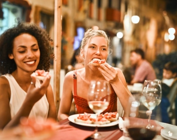 Two women enjoying delicious food at a restaurant