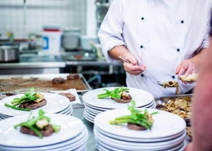 A chef preparing plates of food in a restaurant