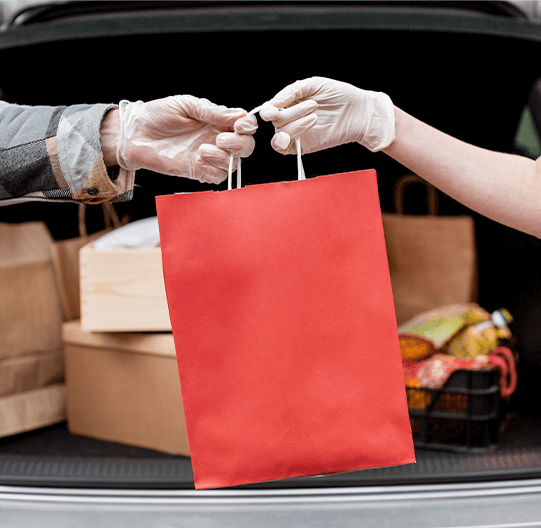 Two people exchanging a red paper bag